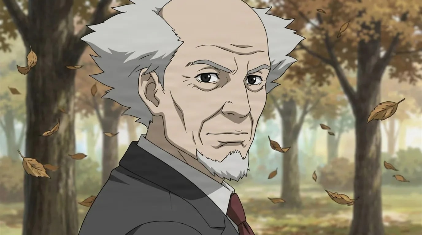 Daisuke Aramaki, an elderly man with spiky gray hair in a suit, stands among autumn trees with falling leaves.
